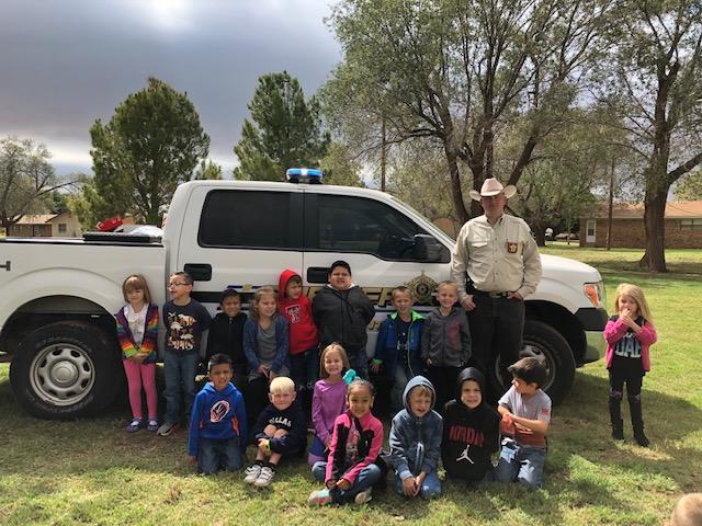 Chief Deputy Timothy Click standing by truck with Kindergarten Class surrounding him